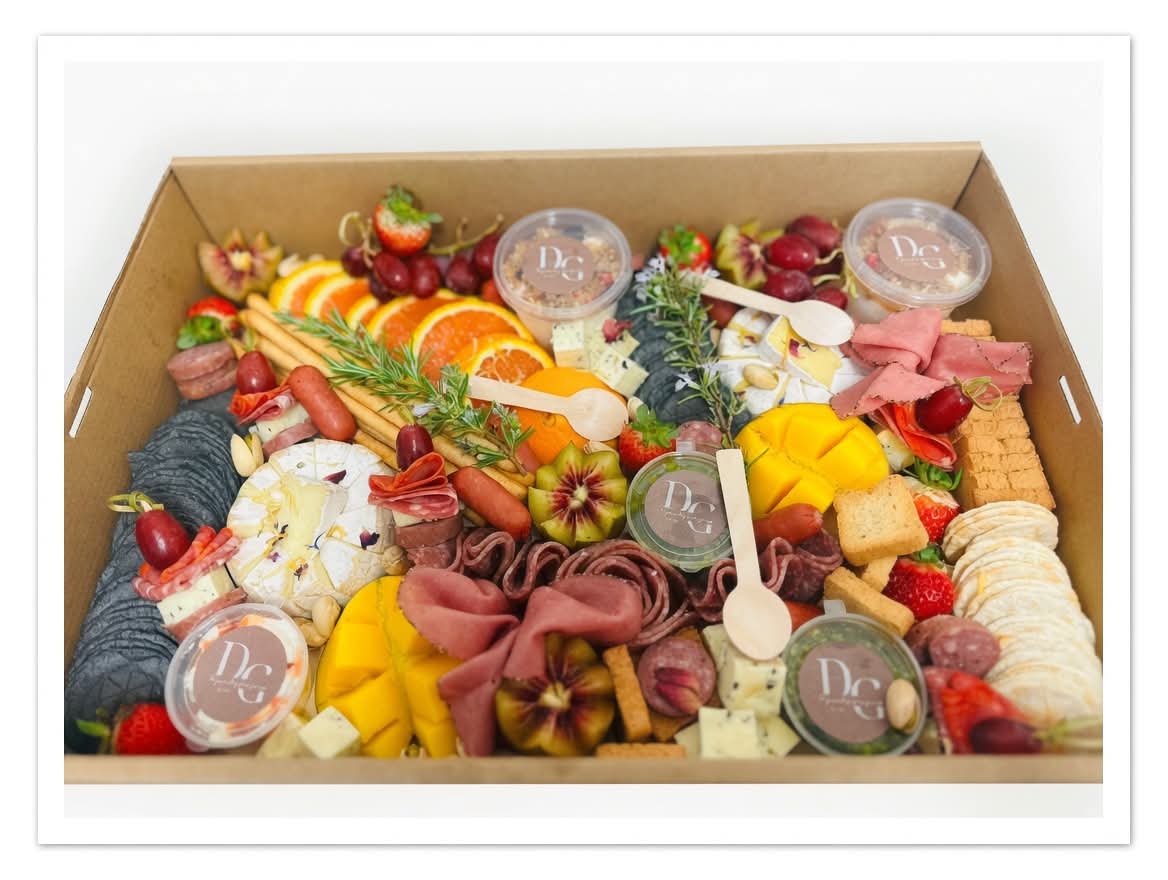Charcuterie grazing platter with cheese, meats, crackers and fruit in a delivery box